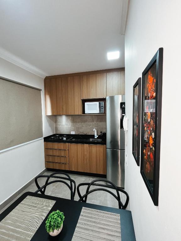 eine Küche mit Tisch und Stühlen und einem Kühlschrank in der Unterkunft Apto 3 PRÓX. Shopping | Hospital Regional, Premium in Três Lagoas