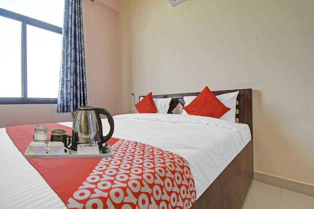a bedroom with a bed with a blender on a table at Hotel O Kalot in Jaipur