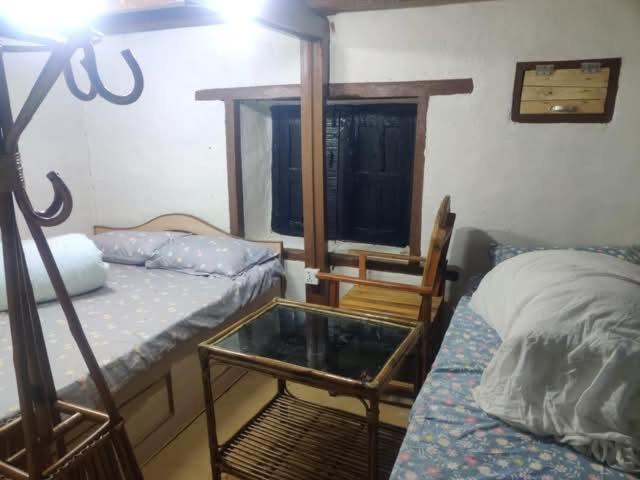 PanaotiBalthali Heritage Inn的带两张床和玻璃桌的房间