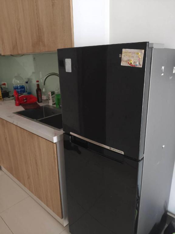 a black refrigerator in a kitchen with a sink at Linh Kinh Bắc in Hòa Bình