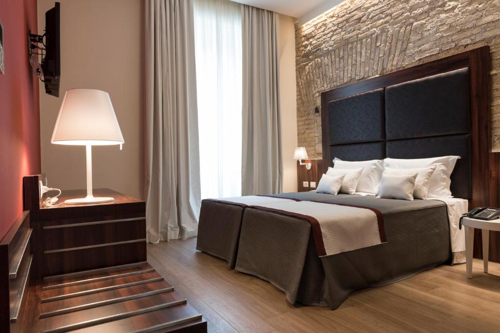 a bedroom with a large bed and a brick wall at Navona Luxury Guesthouse in Rome