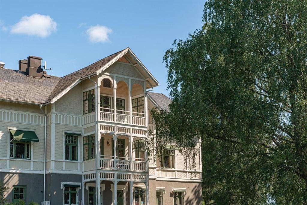 a large white house with a large balcony at Skogsbrynet B&B, Bredsjö Nya Herrgård in Hällefors