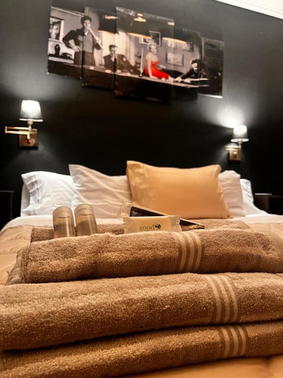 a bed with a pile of towels on top of it at Depto Boutique Chivilcoy in Chivilcoy