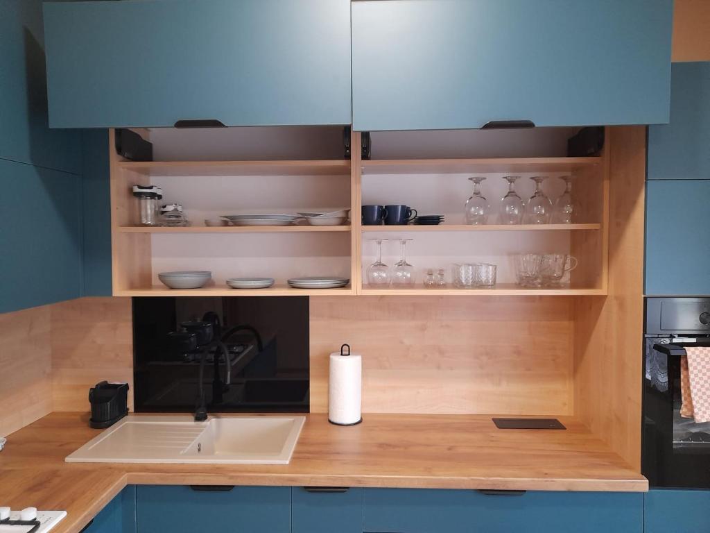Una encimera de cocina con fregadero y microondas. en Mieszkanie w centrum Gogolina, en Gogolin