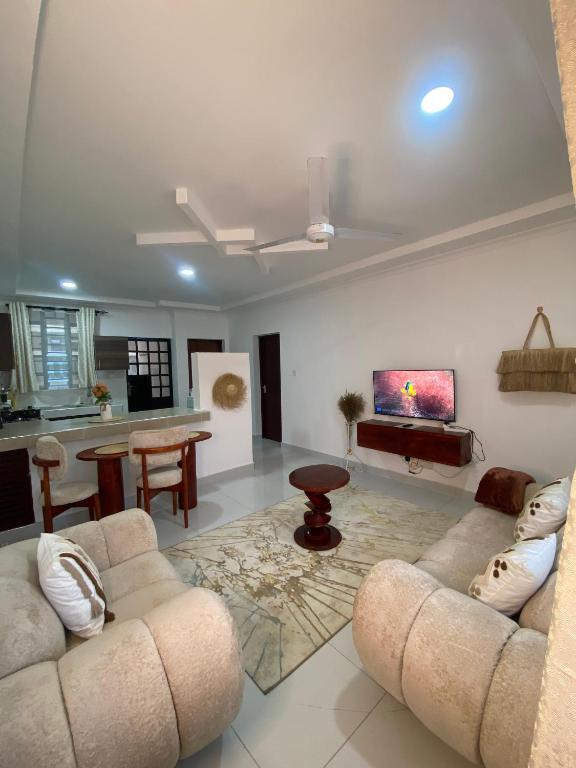 a living room with two couches and a kitchen at Boho Comfort Homes in Diani Beach