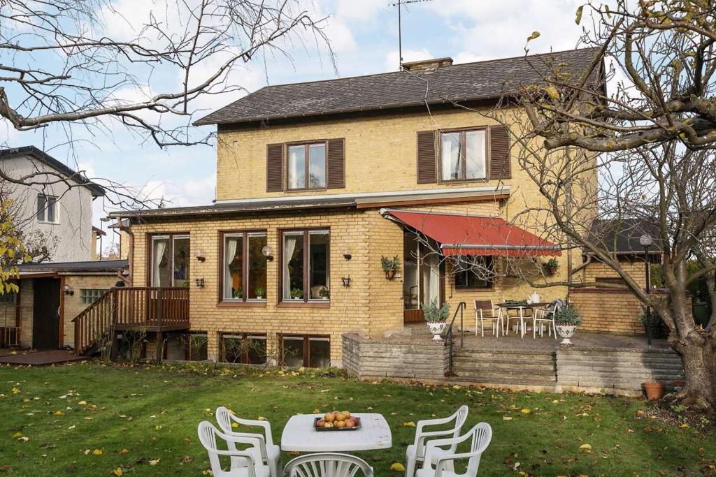 a house with a table and chairs in the yard at Villa Room in Malmö