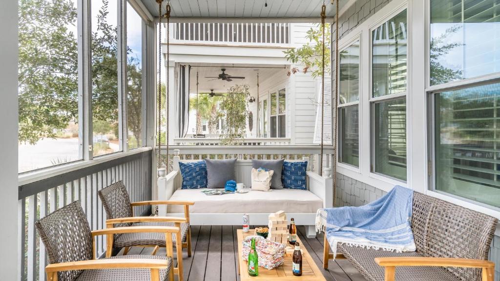 una cama en un porche con sillas y una mesa en Pearl by AvantStay Idyllic Seaside Getaway w 2 Large Decks Lush Garden, en Seagrove Beach