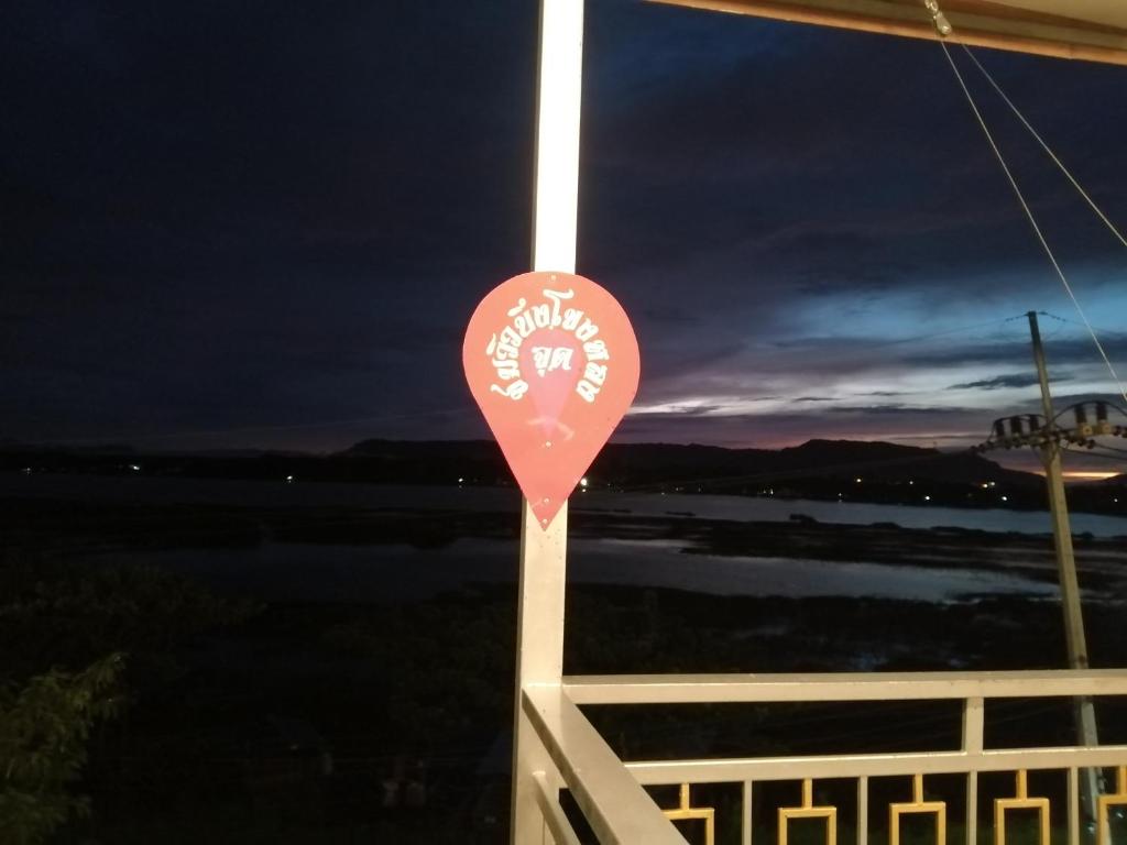 a red flag hanging from a balcony at night at ชมวิว บึงโขงหลง in Ban Don Klang