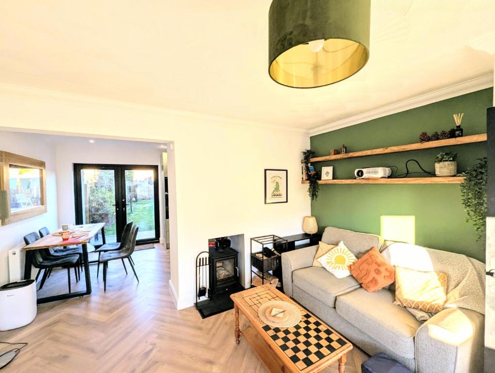 a living room with a couch and a table at Cosy Family-Friendly Stay with 2-Sided Wood Burner in the City of Edinburgh in Edinburgh