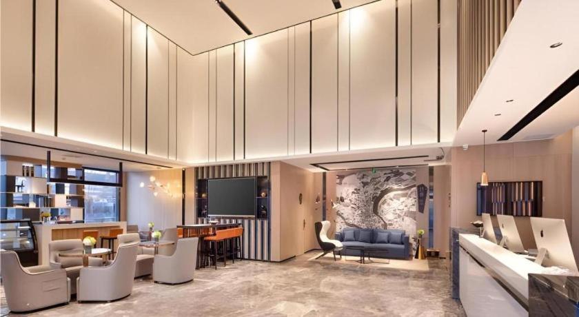 a large living room with a couch and a tv at Echarm Hotel Shenyang Zhongjie North Station Metro Station in Shenyang