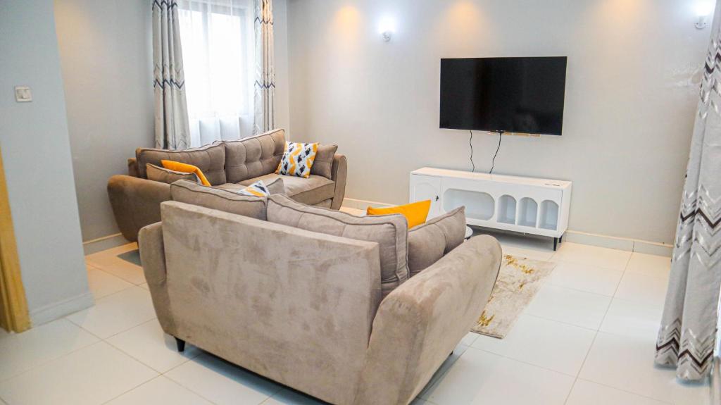 a living room with two couches and a flat screen tv at Parklands Modern 1-Bedroom Apartment near Aga Khan & Diamond Plaza in Nairobi