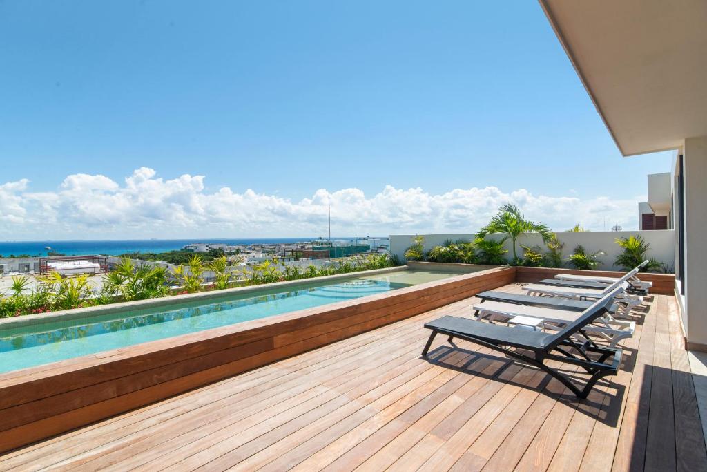 eine Terrasse mit Stühlen und ein Pool auf einem Gebäude in der Unterkunft Paravian by Casago in Playa del Carmen