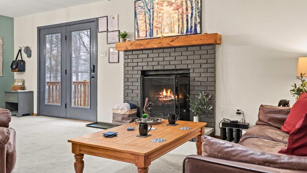 a living room with a fireplace and a wooden coffee table at Hidden Bear by AvantStay A Central Location in Albrightsville