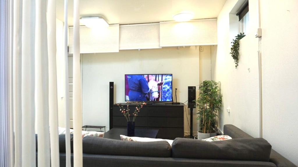 un salon avec un canapé et une télévision dans l'établissement Fresh And Cozy Little House 30km In Täby, à Stockholm
