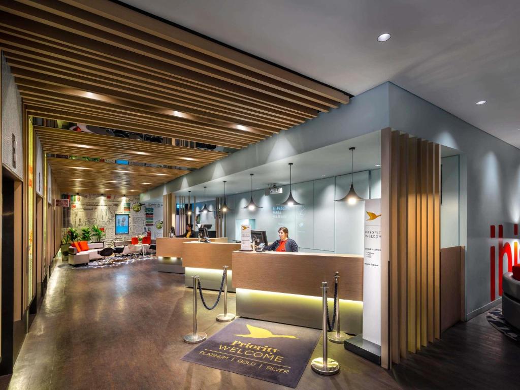 a lobby of an office building with a reception desk at ibis Melbourne Hotel and Apartments in Melbourne