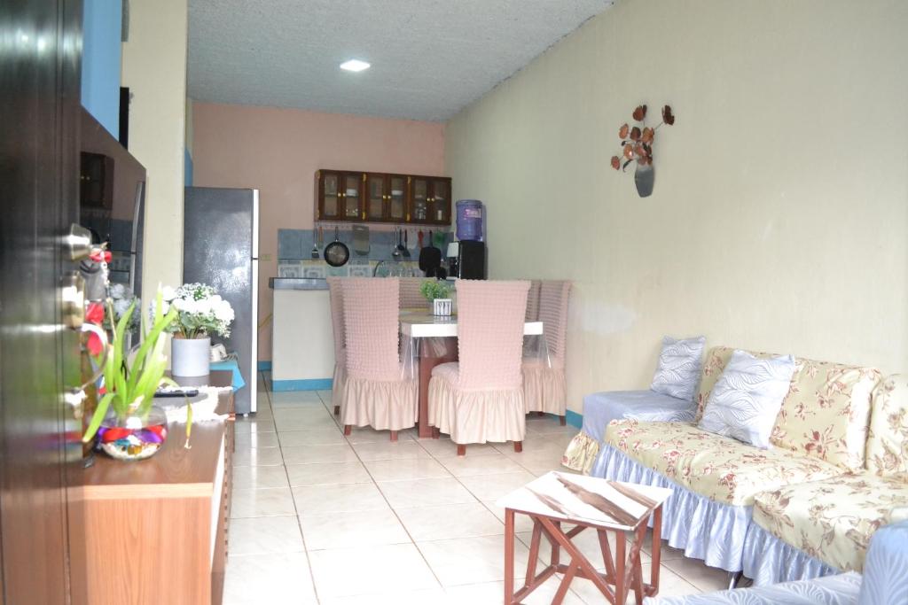 a living room with a couch and a table with chairs at Casa Albacora in Puerto Baquerizo Moreno