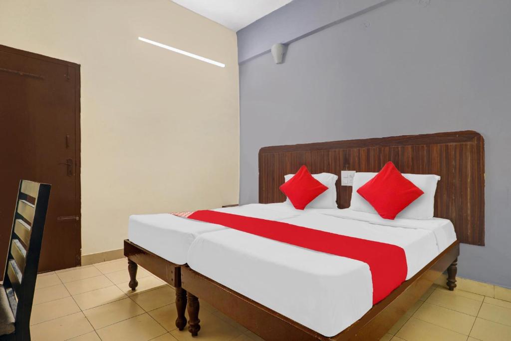 a bedroom with a bed with red and white pillows at Hotel O HRR Hotels Near Paradise circle in Hyderabad