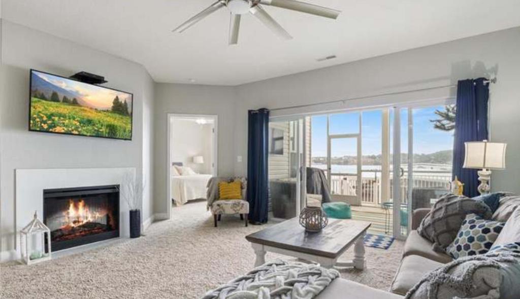 Una sala de estar con un sofá y una chimenea. en 3BD 3BA Gated Condo LakeFront Lake Ozark, MO Isla Del Sol 4 M from Dam, en Rocky Mount