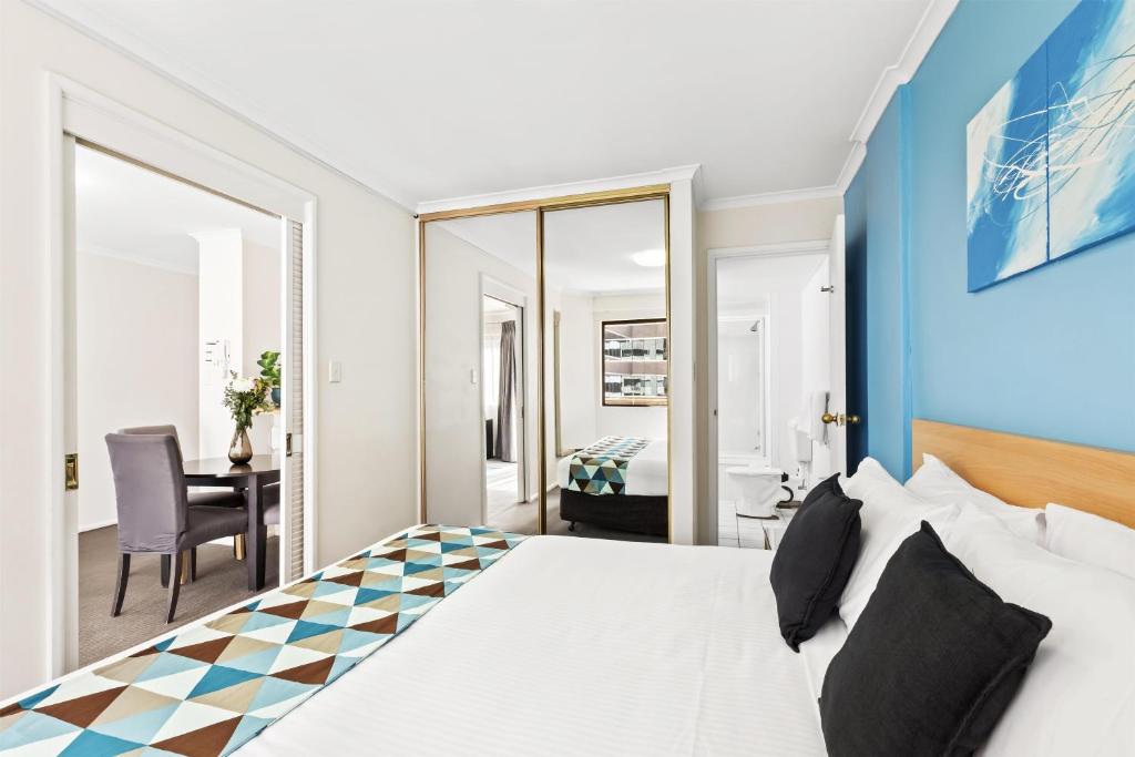 a bedroom with a large bed with a checkerboard floor at Metro Apartments on King in Sydney
