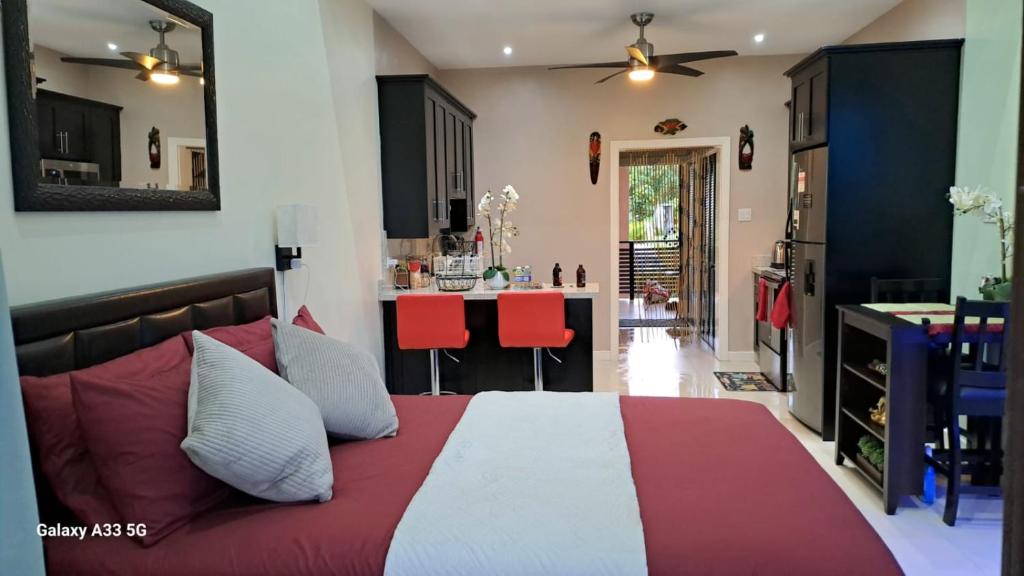 a bedroom with a large bed with red and white pillows at Sunshine Peace and Tranquility in Negril