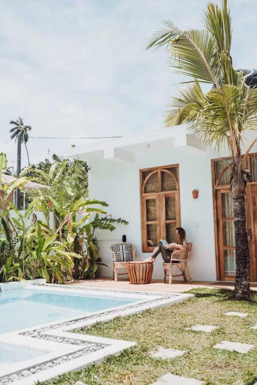 a woman sitting in a chair next to a house at The Oasis Villa in Ahangama