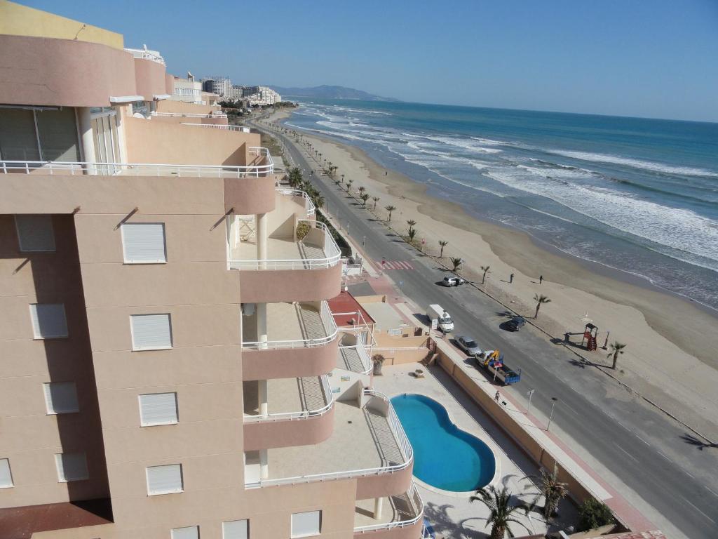 a view of the beach from the balcony of a building at Apartamentos Raymar in Oropesa del Mar