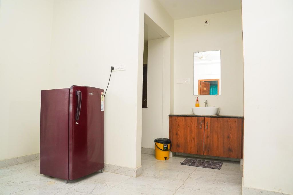 a kitchen with a refrigerator and a sink at Shree Varahi HomeStay in Tirupati