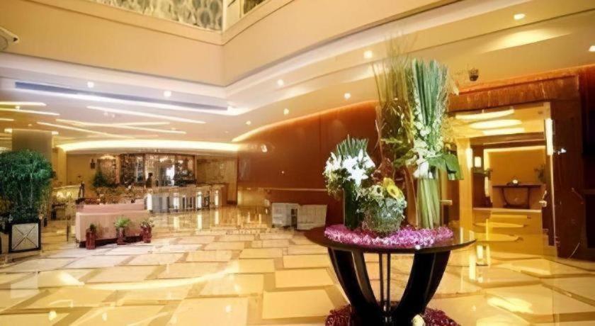 a lobby of a hotel with a table with flowers at Ramada by Wyndham Wujiaochang Shanghai in Shanghai