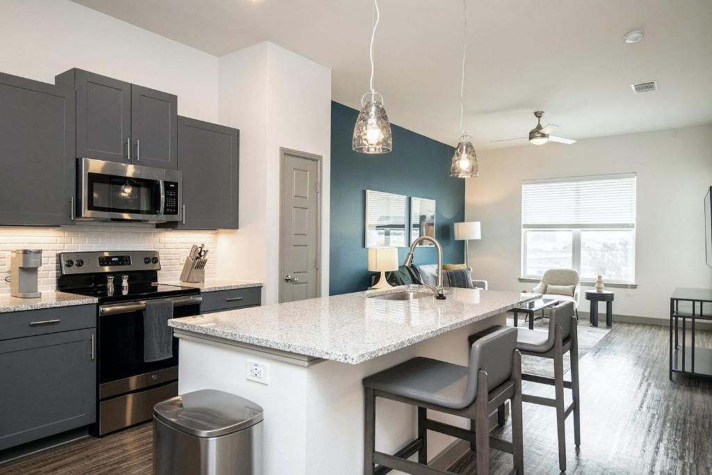 a kitchen with black cabinets and a kitchen island with chairs at Landing Amazing 1BD Clubhouse Pool in Oxford