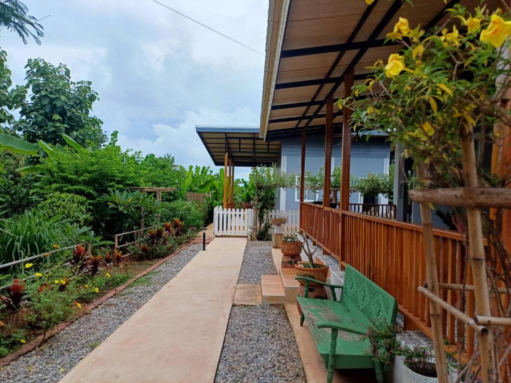 un jardin avec des bancs et une maison avec une clôture dans l'établissement โฮมสเตย์ ยายหนั่น, à Chaiyaphum