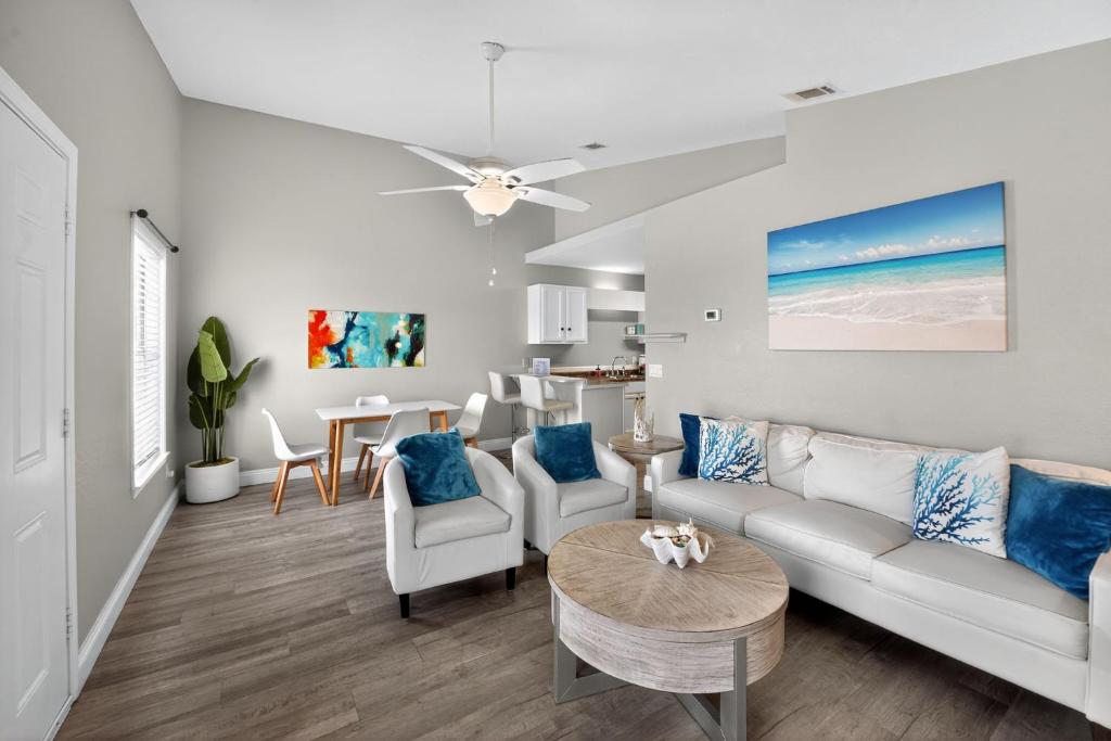 ein Wohnzimmer mit Sofa, Stühlen und einem Tisch in der Unterkunft Luxury Beach Access in Panama City Beach