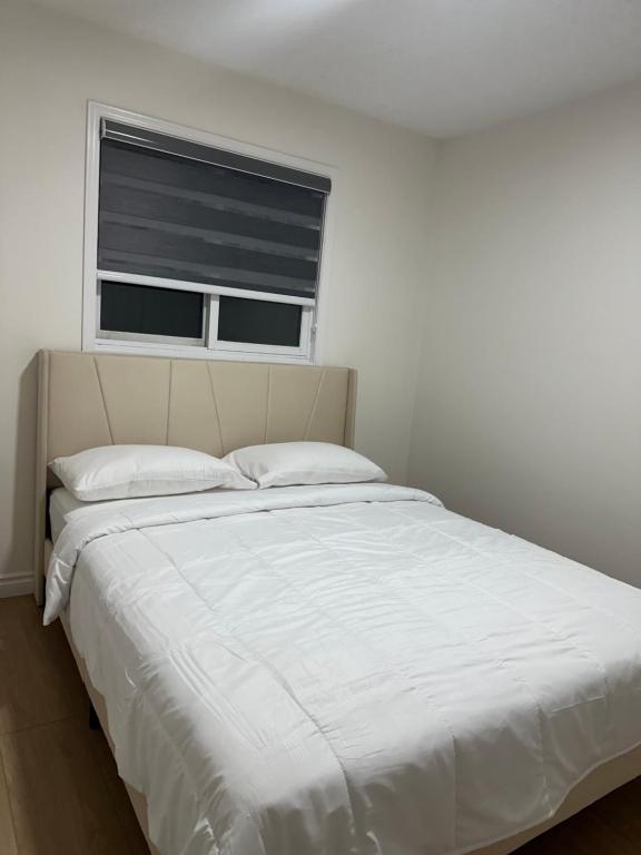 een wit bed in een slaapkamer met een raam bij Peaceful- King Beds- Attached Garage - Pet Friendly in Edmonton