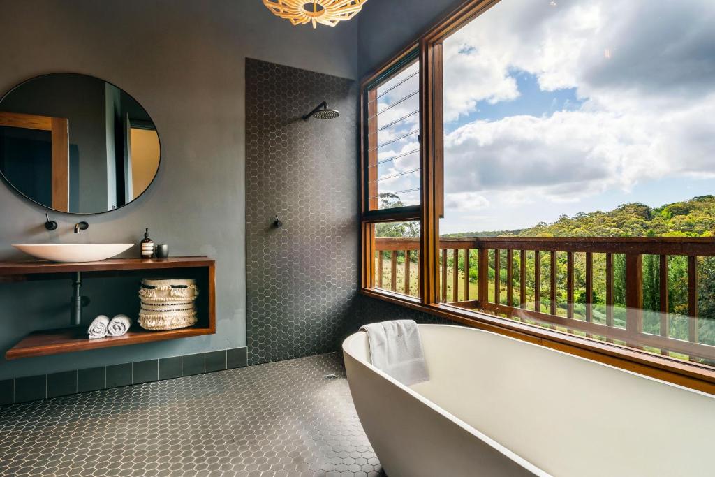 a bathroom with a tub and a sink and a window at Whistlewood - Stunning Views in the Adelaide Hills in Upper Sturt