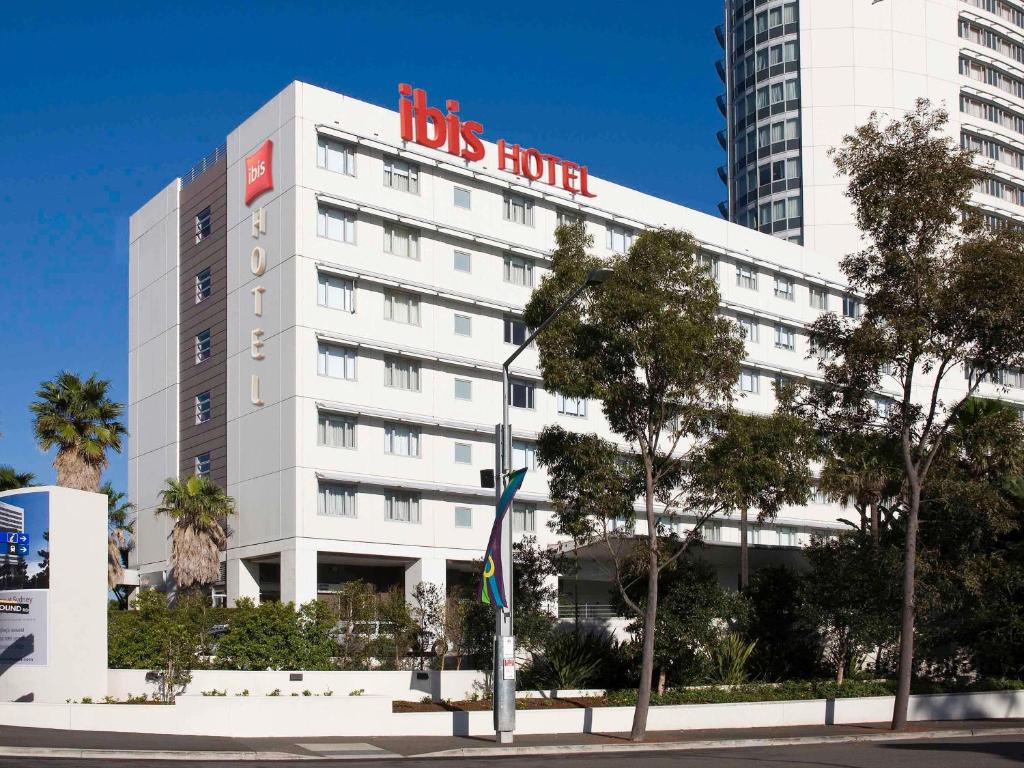 a big white building with a big sign on it at ibis Sydney Olympic Park in Sydney