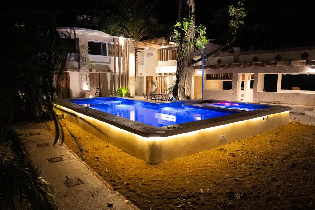 Una piscina con luces frente a una casa. en Dreamcatcher Luxury, en Santa Teresa Beach