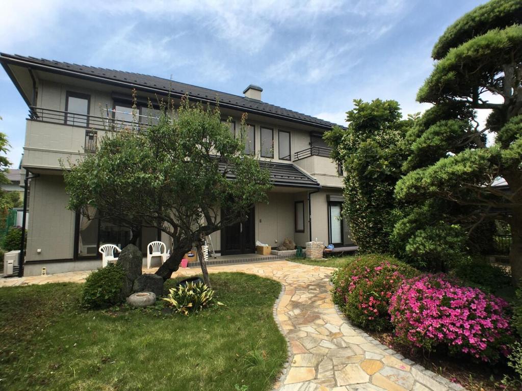 a house with a tree and flowers in the yard at Kamakura Guest House 3 Bedrooms, Sleeps 10 in Kamakura