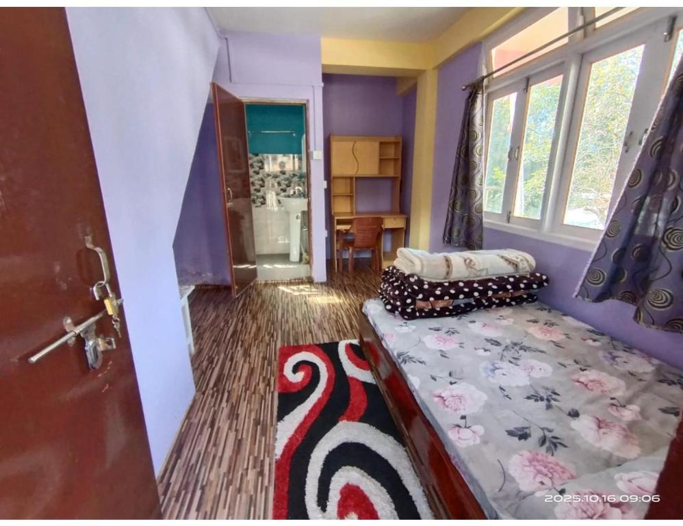 a room with a bed in a room with a door at Ngima woizer Homestay,Tawang in Tawang