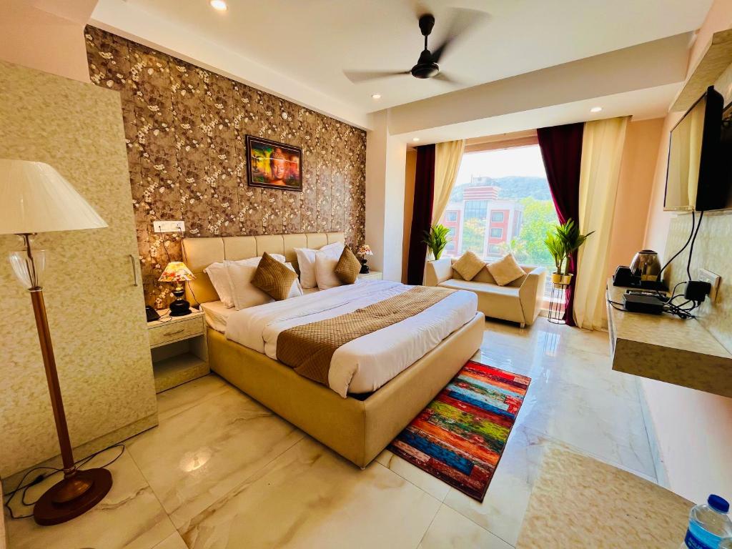 a bedroom with a king sized bed and a couch at Hotel Amritsar View with Swimming Pool - Best Selling Hotel in Amritsar near Golden Temple in Amritsar