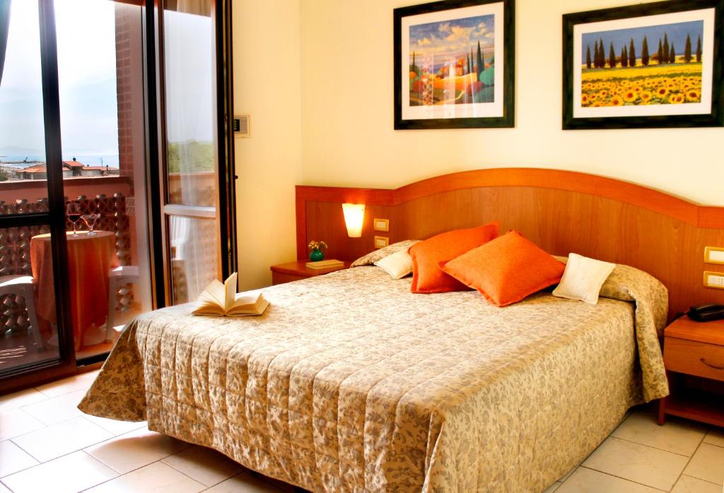 a bedroom with a bed and a balcony at Hotel Ariston in Marina di Grosseto
