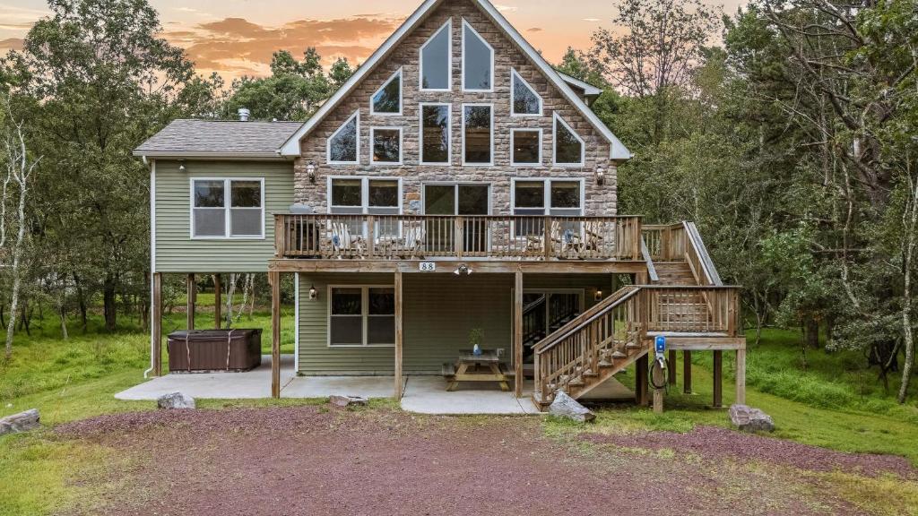 a house with a wrap around porch and a deck at Otter Banks by AvantStay Sleeps 18 Hot Tub Views Game Room in Albrightsville