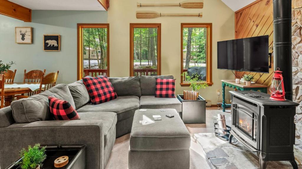 a living room with a couch and a fireplace at Deer Hollow by AvantStay Big Yard Lake Access in Albrightsville