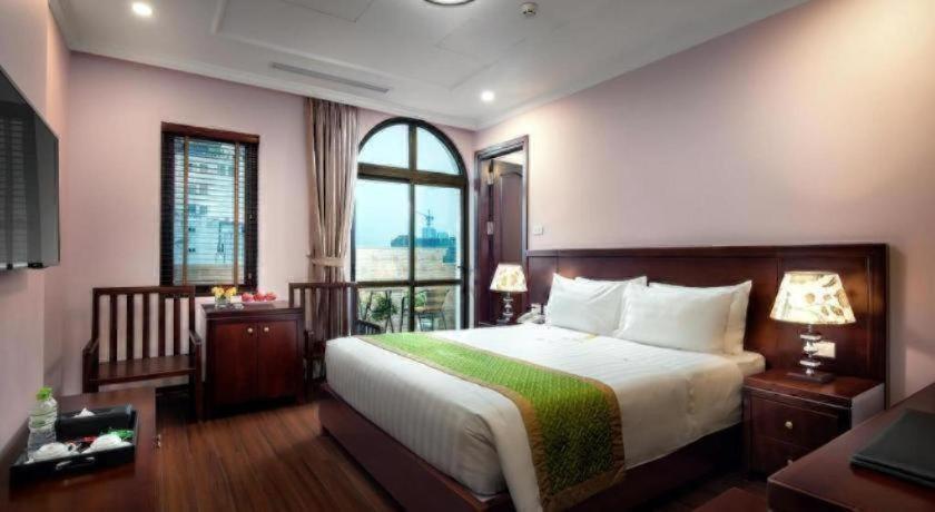 a bedroom with a large bed and a window at Binh Anh Hotel Hanoi in Hanoi