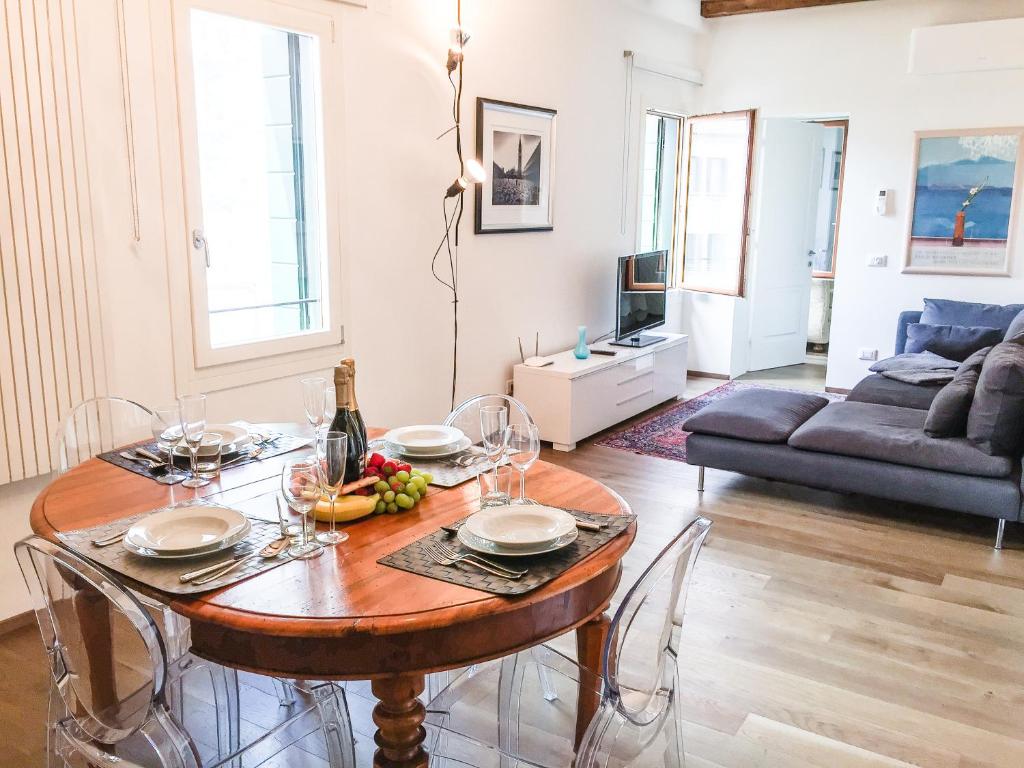 ein Wohnzimmer mit einem Tisch und einem Sofa in der Unterkunft Cà Farnese in Venedig