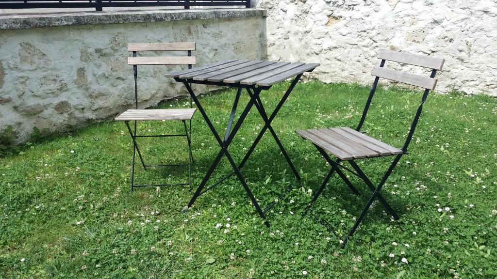 two chairs and a wooden table and two chairs at La Vannerie in Béthisy-Saint-Martin