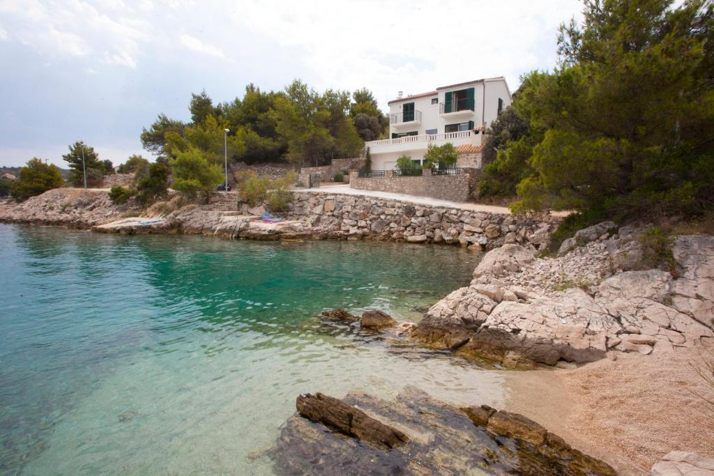 un cuerpo de agua con una casa en el fondo en Villa Perun, en Ražanj