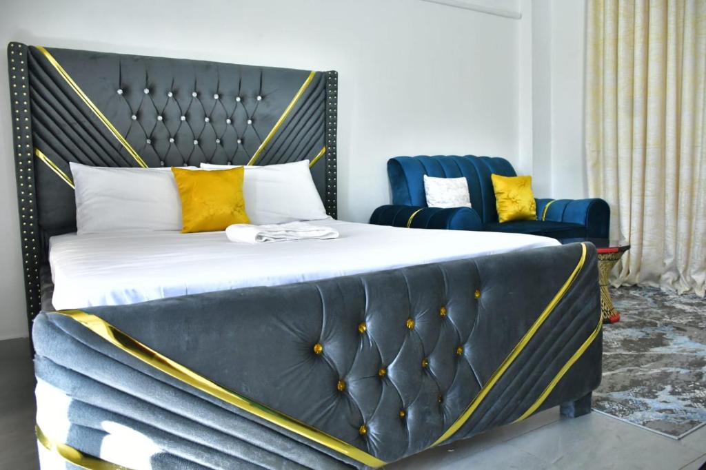 内罗毕Crystal Zuri Homes, Kasarani的一张带黄色枕头和蓝色椅子的床