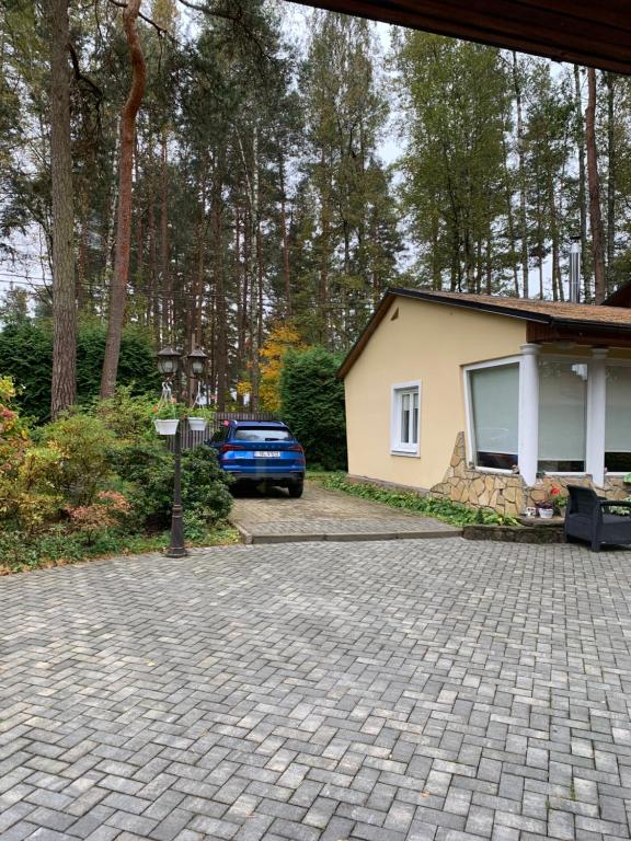 a house with a car parked next to a driveway at Apartment in a quiet area, near the sea and forest in Jūrmala