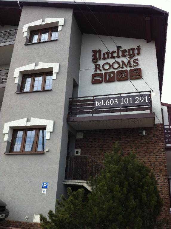 a building with a sign on the side of it at Route 7 Rooms in Myślenice