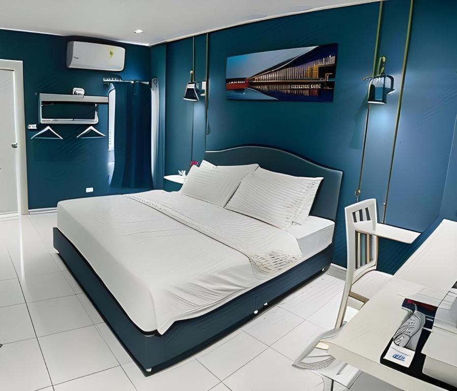 a blue bedroom with a bed and a desk at HUBBLE HOTEL in Hat Yai