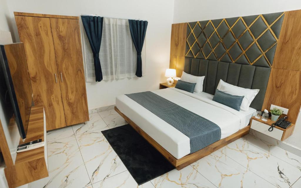 a bedroom with a large bed and a window at Hotel Maya Elite in Bhopal
